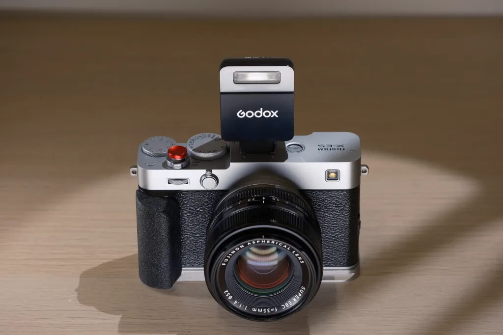 Накамерний спалах Godox iT22 у чорному корпусі встановлений у гарячий башмак фотоапарата Fujifilm X-E3 з об'єктивом 35 мм