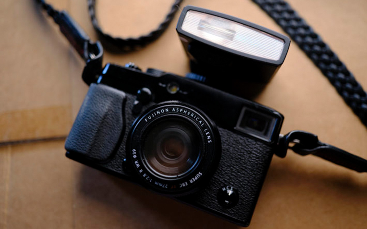 Спалах Godox Lux Junior закріплений на башмаку камери Fujifilm, видно текстуровану передню панель корпусу.